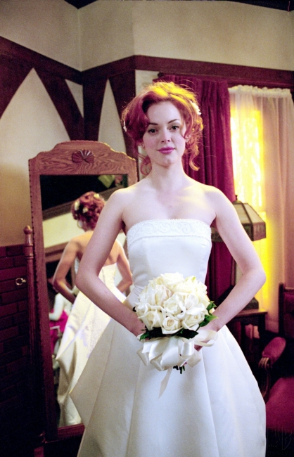 Paige avec une robe de mariée s'apprête à prendre la place de la vraie mariée